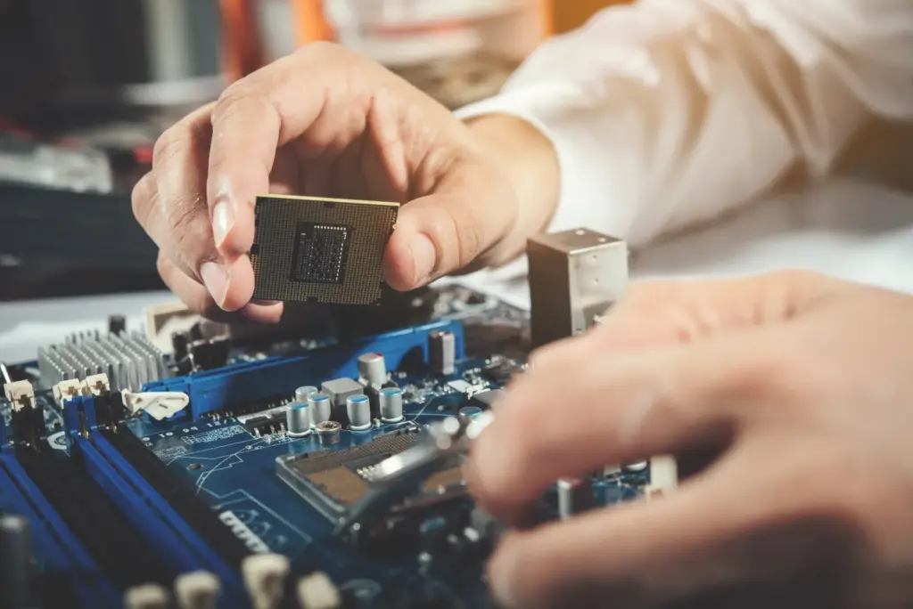 Technician working inside a desktop computer on a repair bench