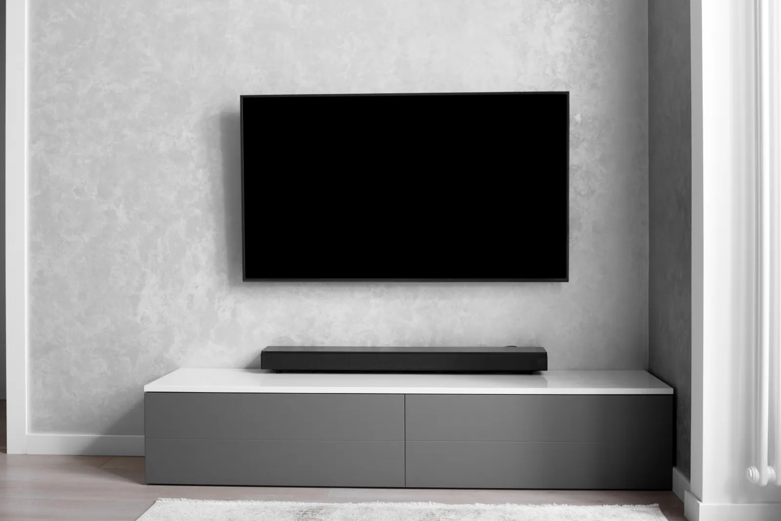 Wall-mounted TV with soundbar and hi-fi equipment in a living room
